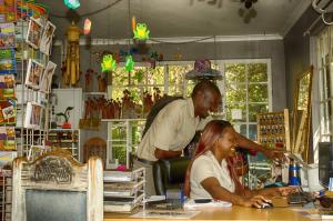 a man and a woman sitting at a table in a shop at The Old House in Kasane