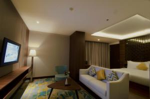 Habitación de hotel con sofá y cama en Grand Soll Marina Hotel en Tangerang