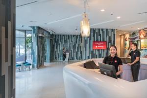 two people standing in the lobby of a building at Travelodge Pattaya in Pattaya