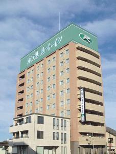 duży budynek z znakiem na górze w obiekcie Hotel Route-Inn Fujieda-Eki Kita w mieście Fujieda