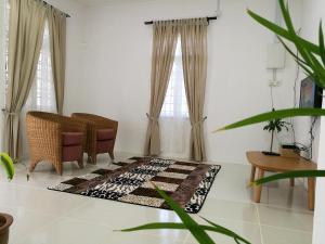 - un salon avec une chaise et un tapis dans l'établissement ALA Beach Lodge - Markisa Homestay, à Bachok