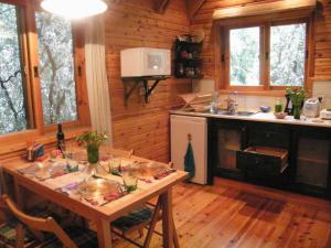 una cocina con mesa en una cabaña de madera en Ronit and Mario, en Abirim