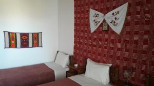 a room with two beds and a clock on the wall at Aris Rooms in Anogeia