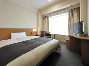a hotel room with a bed and a television at Hotel Crown Palais Kitakyushu in Kitakyushu +31 photos