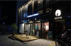 a hotel with a table and chairs outside at night at Hotel The Designers Hongdae in Seoul