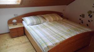 małą sypialnię z łóżkiem i szafką nocną w obiekcie Leitingerhof w mieście Thalgau