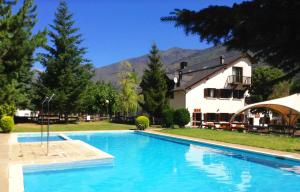 a large blue swimming pool in front of a house at Aiguestortes Camping Resort in Esterri d'Àneu