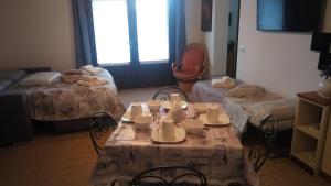 ファーノにあるB & B LE TRE Bのベッド2台、テーブル、椅子が備わる客室です。