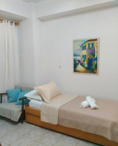 a bedroom with two beds and a painting on the wall at Polymnia's apartment in Matala