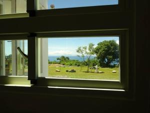 a window with a view of a field of sheep at The Song of Eagle in Donghe