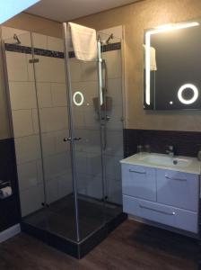 a bathroom with a shower with a sink and a mirror at Pension Schmitz in Serrig +28 photos