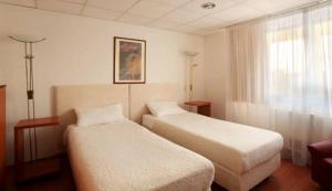 Habitación de hotel con 2 camas y ventana en Sós Motel, en Hatvan