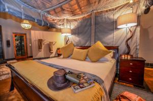 um quarto com uma cama de dossel e uma arma. em Nkorho Bush Lodge em Sabi Sand Game Reserve