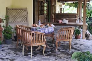 une table et des chaises dans une terrasse avec piano dans l'établissement Puri Brata, à Parangtritis