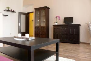 a room with a table and a cabinet and a television at Ferienwohnung Luisenstraße in Görlitz