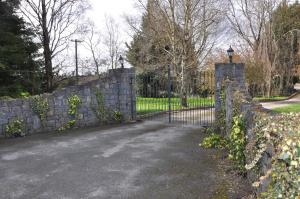a stone fence with a gate and a stone wall at Delphi Lodge in Donaghmore