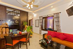 a living room with a red couch and a table at Pham Gia Boutique Villa in Hoi An