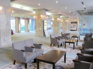 a lobby with chairs and tables in a building at Hotel Crown Palais Kitakyushu in Kitakyushu