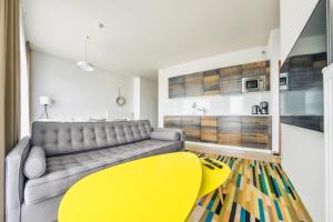 a living room with a couch and a yellow chair at Prywatne apartamenty Sun & Snow w Baltic Park Molo in Świnoujście