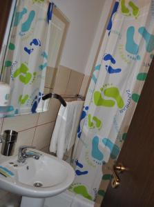 a bathroom with a sink and a shower curtain at Delta Marina in Sfântu Gheorghe