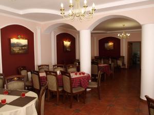 Un comedor con mesas y sillas y una lámpara de araña. en Recreation Complex Sunny Resort, en Polyana