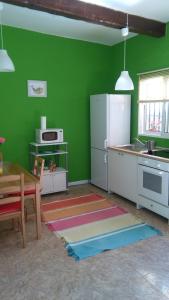 eine grüne Küche mit Tisch und Kühlschrank in der Unterkunft La Casita de Silvia in Alhaurín de la Torre
