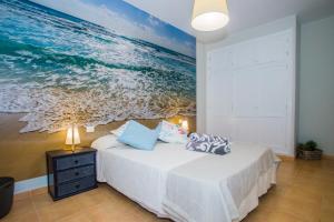 カレタ・デ・ファマラにあるFamara Views IIIのベッドルーム1室(海の絵画付)