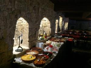 einen Tisch mit Essen darauf in einem Steinzimmer in der Unterkunft Selcuklu Evi Cave Hotel - Special Category in Ürgüp