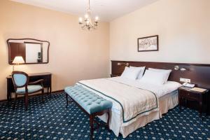 a hotel room with a bed and a chair and a mirror at Sun Hotel in Irkutsk