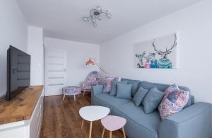 ein Wohnzimmer mit einem blauen Sofa und einem Tisch in der Unterkunft Apartament Stag Azyl na szczycie - 2 osobne pokoje - by Space Apart in Jelenia Góra