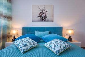1 dormitorio con 1 cama azul y 2 almohadas en Apartament Stag Azyl na szczycie - 2 osobne pokoje - by Space Apart, en Jelenia Góra