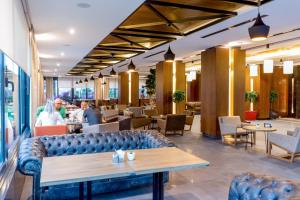 a restaurant with a couch and tables and chairs at Vista Hotel in Mezitli