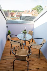 a small balcony with a glass table and chairs at Apartmány u sv. Kryštofa in Bzenec