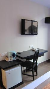 a black desk with a television on a wall at Good Hope Hotel Kelana Jaya in Petaling Jaya