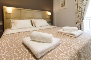 a large bed with two white towels on it at Luxury Apartment Philoxenia in Thessaloniki