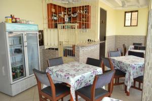 a dining room with two tables and a refrigerator at Barcelona Lodge in Bagamoyo