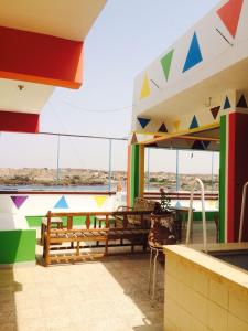 a patio area with tables, chairs and umbrellas at Ekadolli Nubian Guesthouse Aswan in Aswan