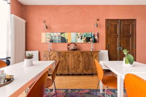 a dining room with orange walls and a wooden cabinet at La casetta di Lu in Cellarengo