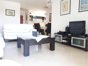 uma sala de estar com um sofá, uma mesa e uma televisão em Shoam street apartment sea view Ashdod em Ashdod