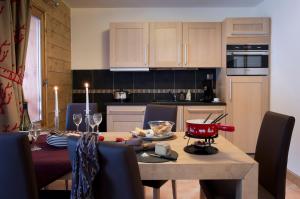 a kitchen and dining room with a table and chairs at CGH Résidence Boutique Le Lodge Hemera in La Rosière +32 photos