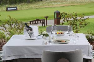 una mesa con un plato de comida y copas de vino en King's and Lake's House Golf Course Royal Bled, en Bled