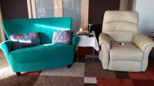 dwa krzesła siedzące obok siebie w salonie w obiekcie Casa Margherita w mieście Villar San Costanzo