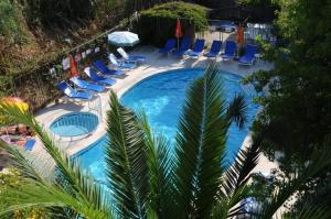an overhead view of a swimming pool with chairs and umbrellas at Caretta Apart in Fethiye