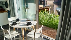 アムステルダムにあるRoom With A Fewのテーブルと椅子、水辺の景色を望むバルコニー