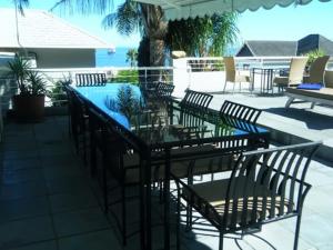 - une table et des chaises sur une terrasse avec piscine dans l'établissement Maison Fontainbleau, au Cap
