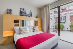 a bedroom with a large bed with a red blanket at Room Mate Alicia, Madrid in Madrid