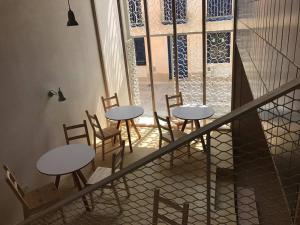 two tables and chairs in a room with a window at Hotel Santacreu in Tabarca