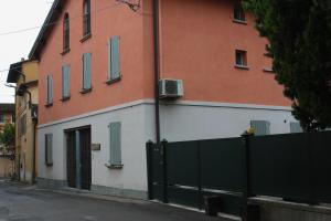 a building with a green fence next to a street at Il Borghetto in Cavriago