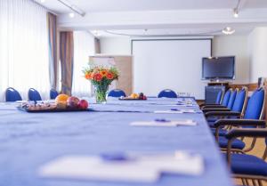 una sala conferenze con un lungo tavolo e un vaso di fiori di Hotel Domicil Berlin by Golden Tulip a Berlino
