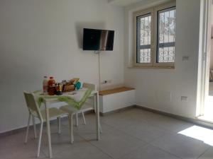 a dining room with a table and chairs and a tv at Casa Lucrino in Pozzuoli